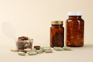 Photo of Pharmacist. Many different pills in plastic container and bottles on beige background