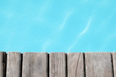 Wooden desk near outdoor swimming pool at resort