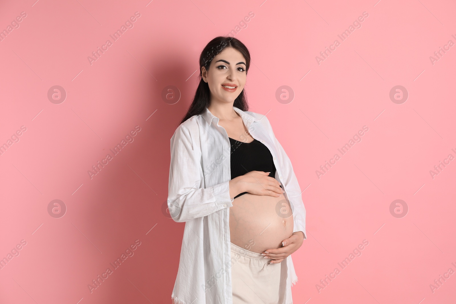 Photo of Portrait of beautiful pregnant woman on pink background