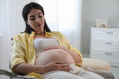 Photo of Young pregnant woman lying on bed at home