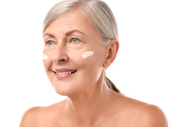 Senior woman with face cream on white background