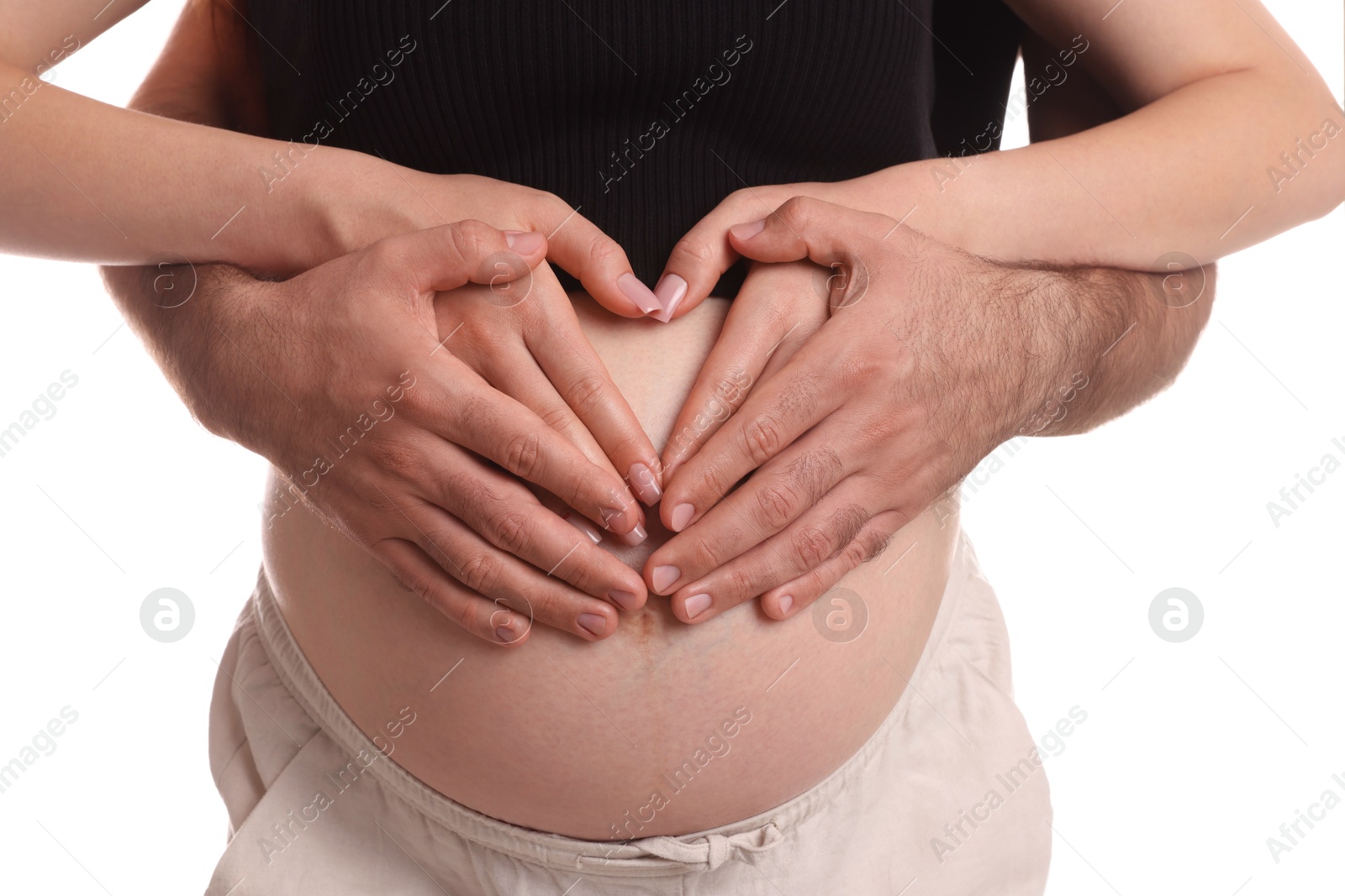 Photo of Pregnant woman and her husband making heart with hands on white background, closeup