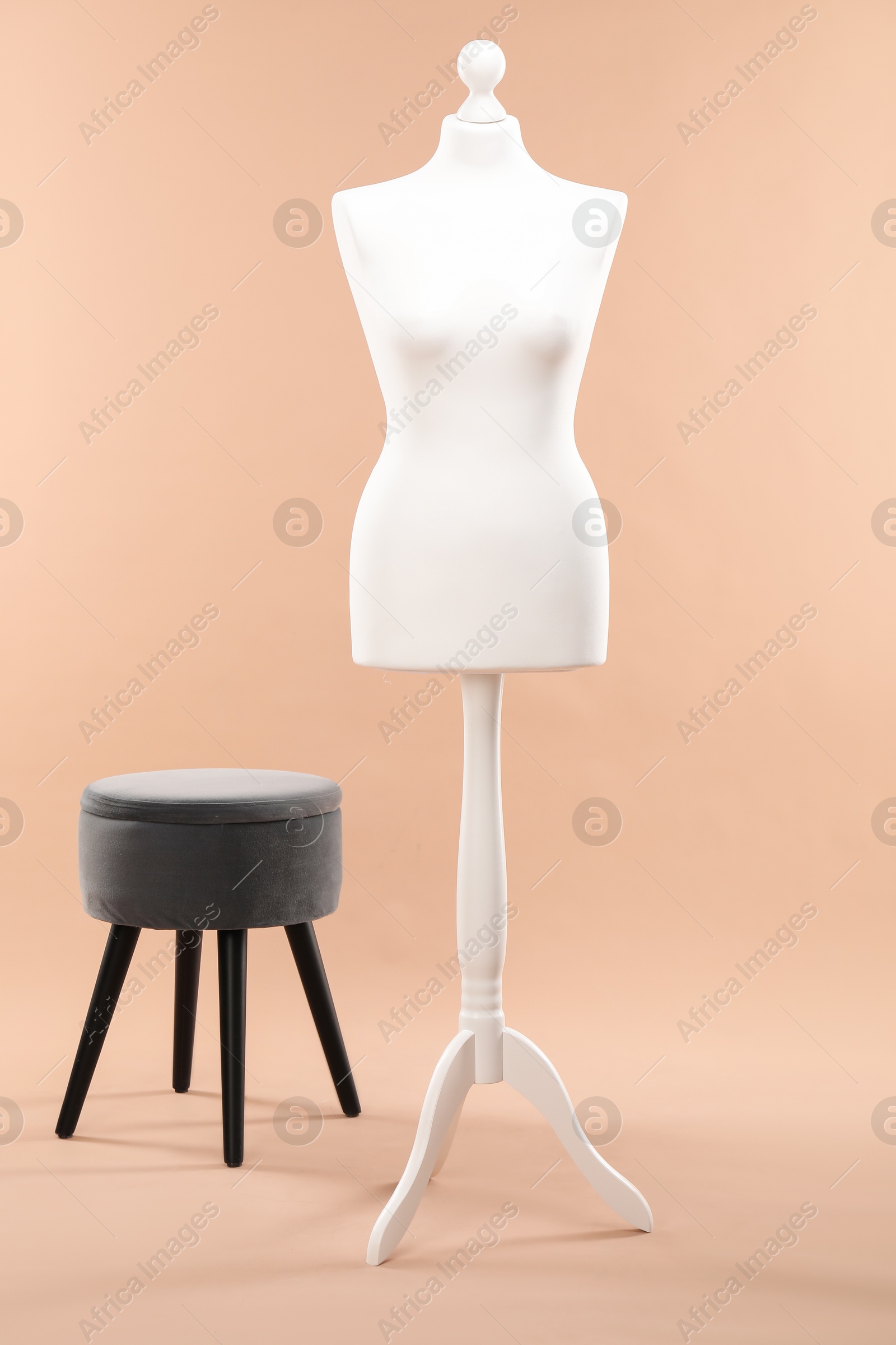 Photo of One female mannequin and ottoman on beige background