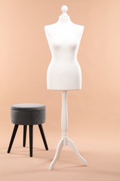 Photo of One female mannequin and ottoman on beige background