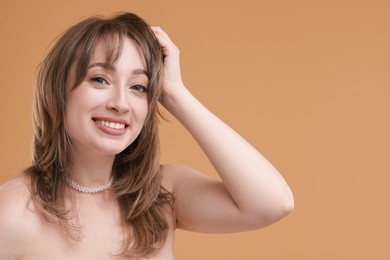 Attractive woman with stylish haircut on beige background