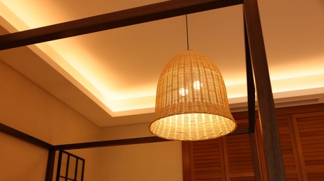 Stylish pendant lamp on ceiling indoors, low angle view