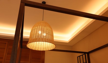 Photo of Stylish pendant lamp on ceiling indoors, low angle view