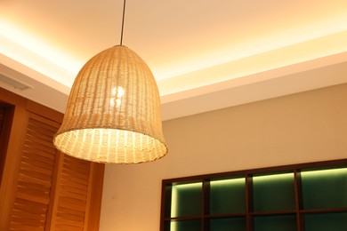 Photo of Stylish pendant lamp on ceiling indoors, low angle view