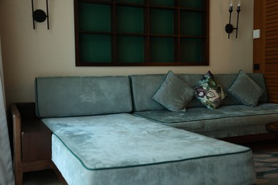 Photo of Comfortable sofa with cushions in hotel room