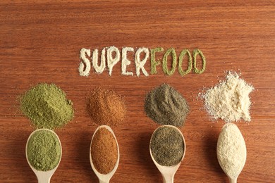 Word Superfood and different healthy powders on wooden table, flat lay