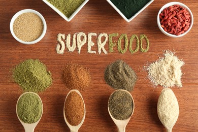 Word Superfood and different healthy powders on wooden table, flat lay