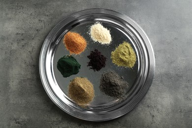 Photo of Different superfood powders on grey table, top view