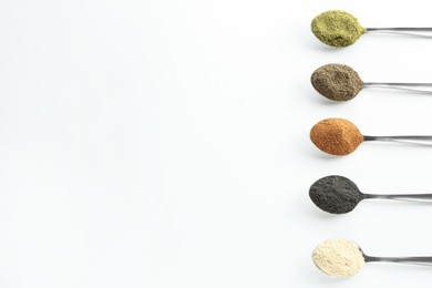 Photo of Different superfood powders in spoons on white background, above view. Space for text