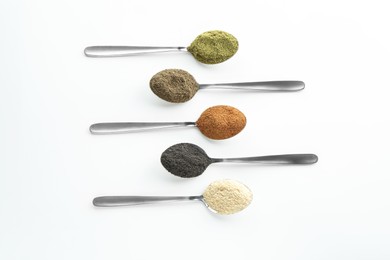 Photo of Different superfood powders in spoons on white background, flat lay