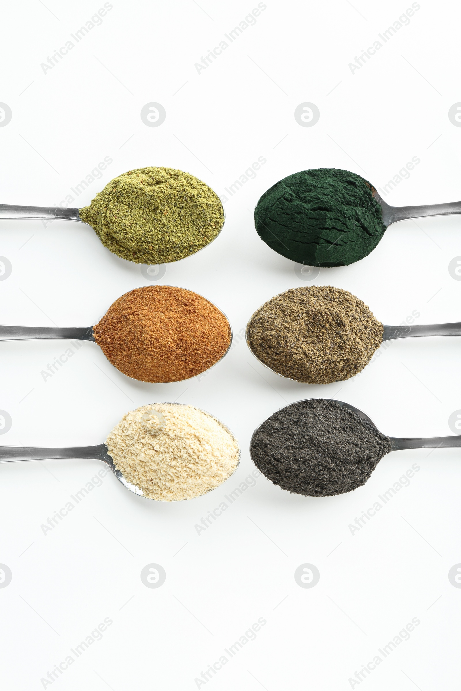 Photo of Different superfood powders in spoons on white background, flat lay