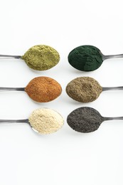 Photo of Different superfood powders in spoons on white background, flat lay