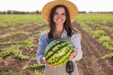 Photo of Woman with ripe watermelon in field on sunny day