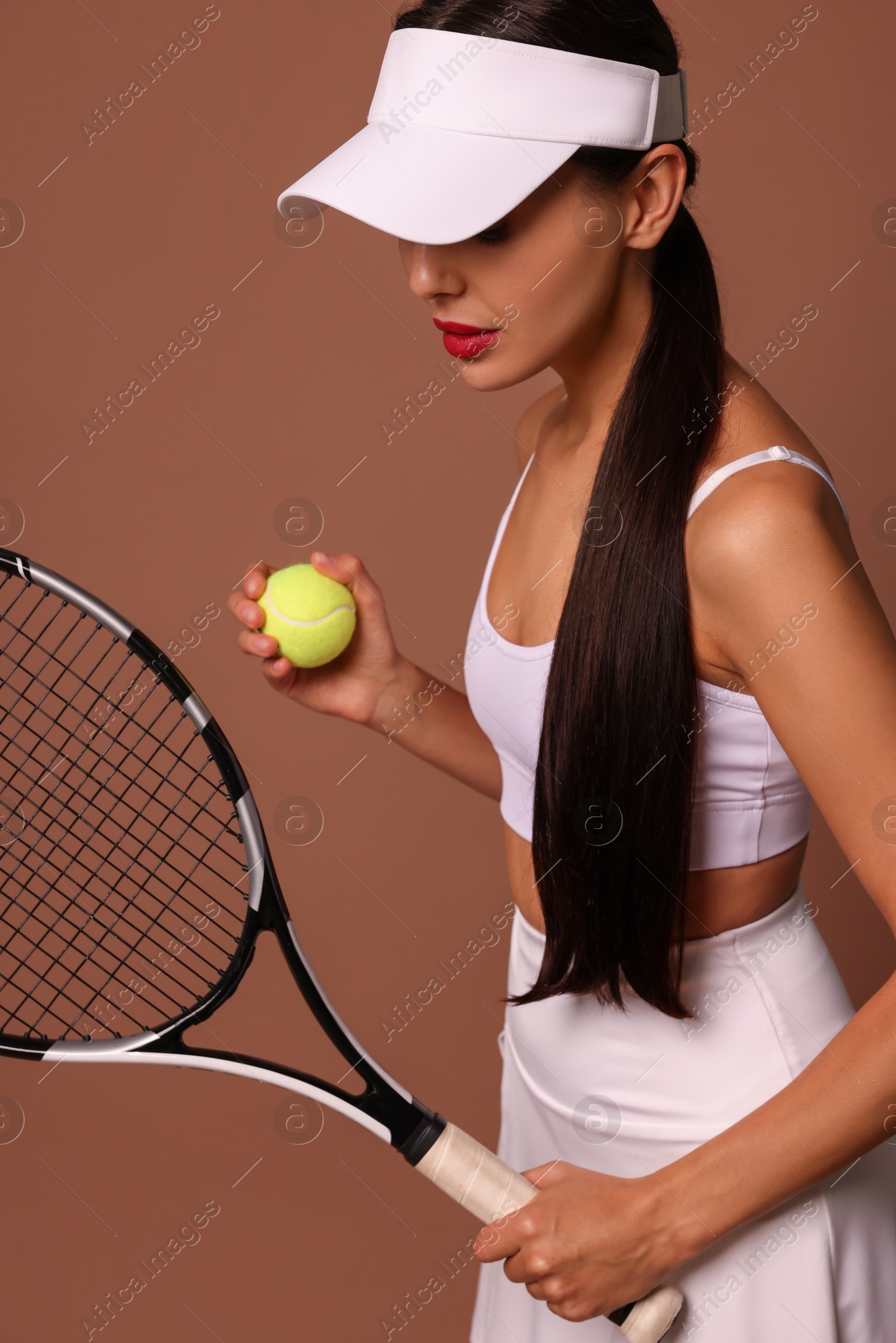 Photo of Tennis player with racket and ball on brown background