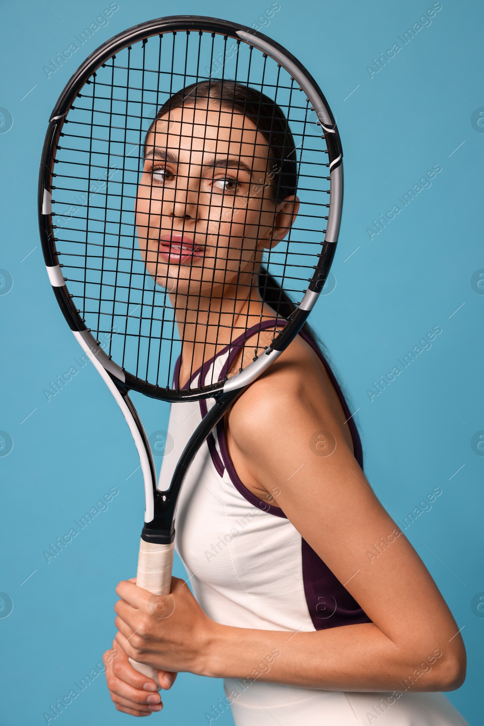 Photo of Beautiful young woman with tennis racket on light blue background