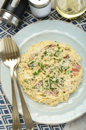 Photo of Delicious pasta Carbonara with bacon served on gray table, flat lay