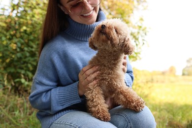 Photo of Smiling woman with cute dog outdoors, closeup