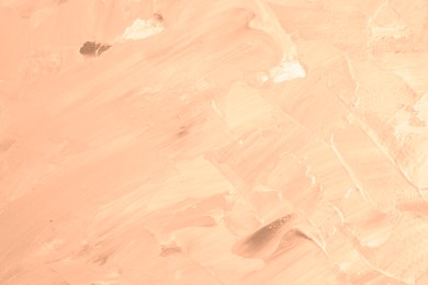 Image of Peach fuzz color paint strokes as background, closeup