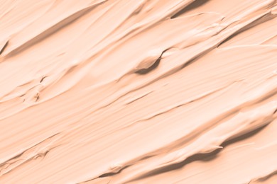 Image of Skin foundation as background, closeup. Peach fuzz color