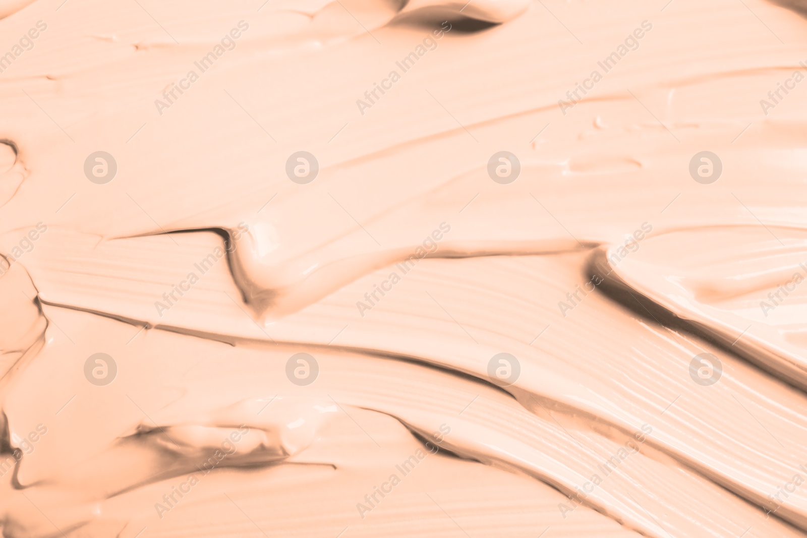 Image of Skin foundation as background, closeup. Peach fuzz color