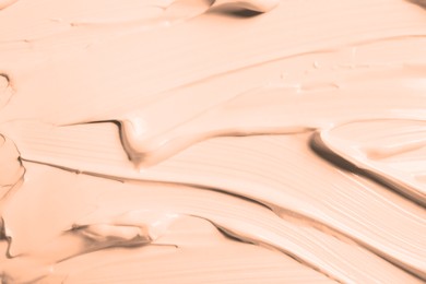 Image of Skin foundation as background, closeup. Peach fuzz color