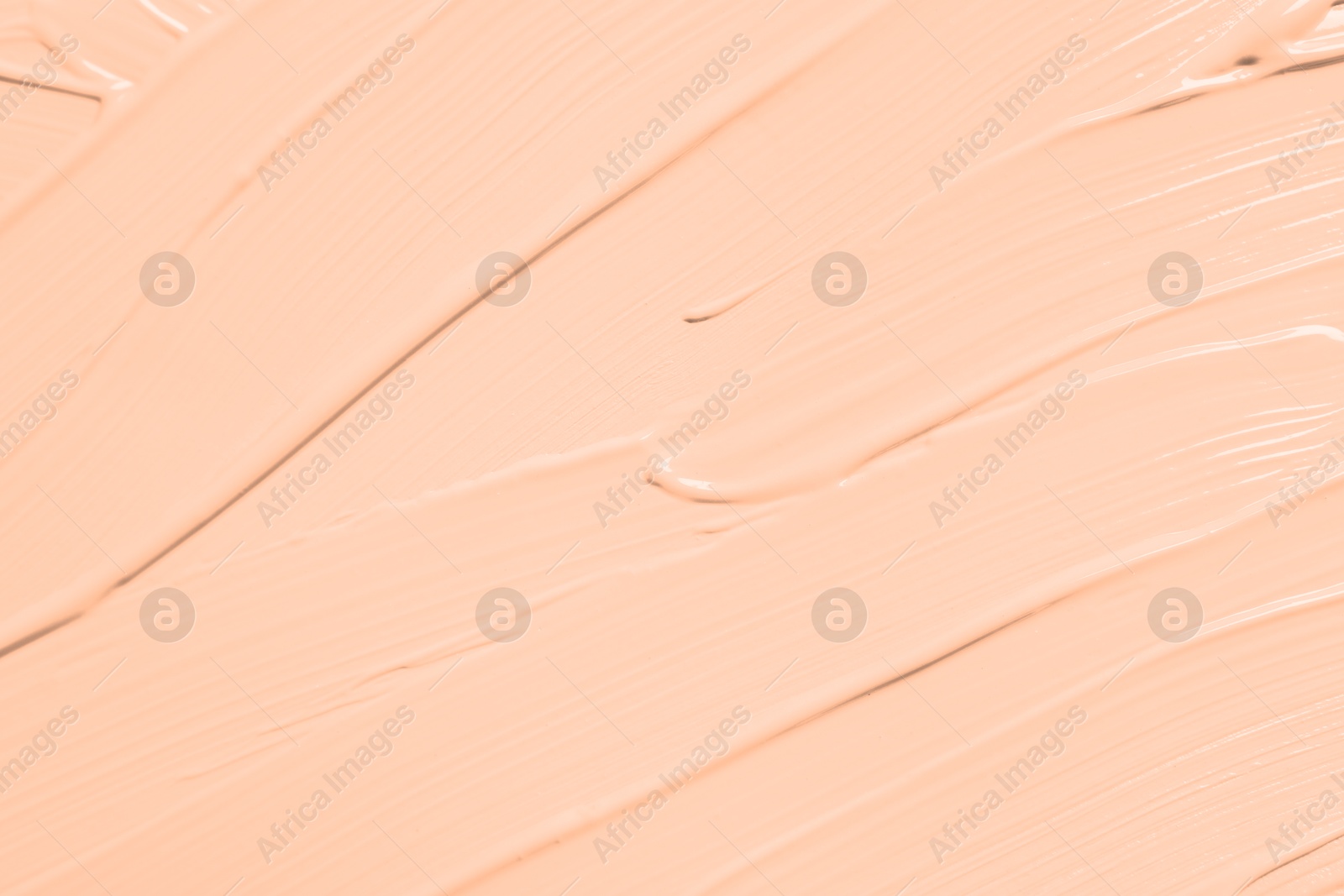 Image of Skin foundation as background, closeup. Peach fuzz color