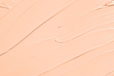 Image of Skin foundation as background, closeup. Peach fuzz color