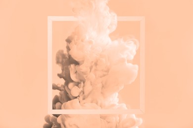 Image of Splash of ink and frame on peach fuzz color background