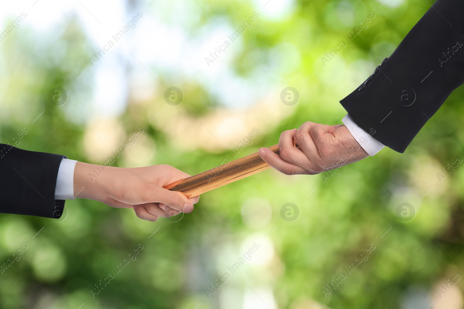 Image of Businessman passing relay baton to colleague outdoors, closeup