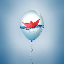 Image of Paper boat floating on water inside balloon against light blue background