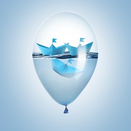 Image of Paper boats and water inside balloon against light blue background