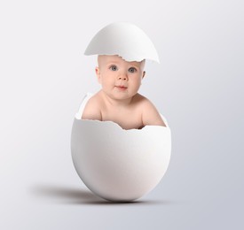 Image of Cute little baby in eggshell on light grey background