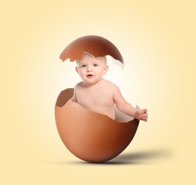 Image of Cute little baby in eggshell on light yellow background