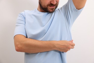 Man after using deodorant on white background, closeup