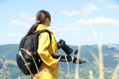 Photo of Photographer with backpack and professional equipment in beautiful mountains