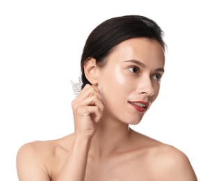 Beautiful woman peeling off face mask on white background