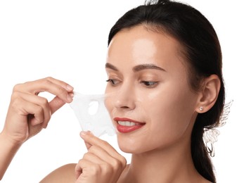 Smiling woman peeling off face mask on white background