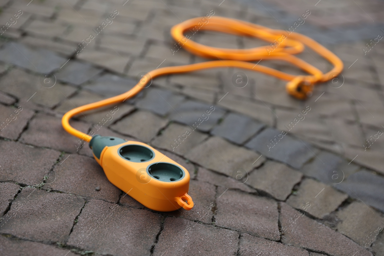 Photo of One extension cord on paved pathway outdoors