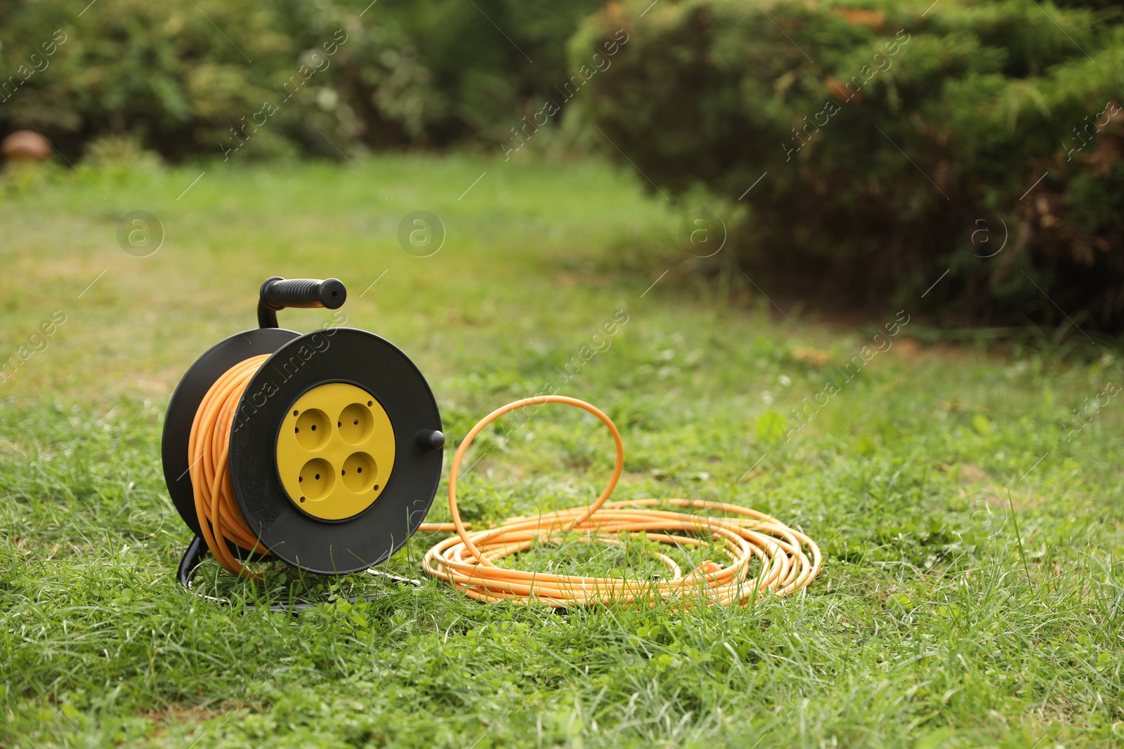 Photo of Extension cord reel on green grass outdoors