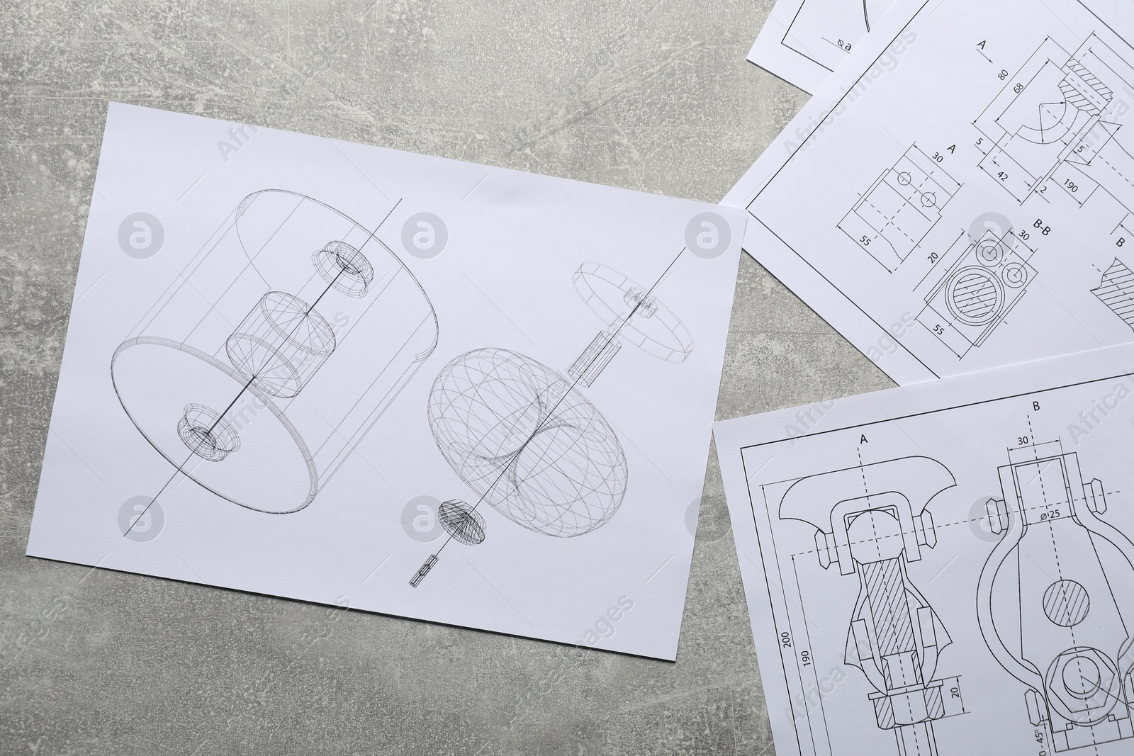 Photo of Different engineering drawings on gray textured table, top view