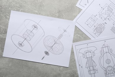 Photo of Different engineering drawings on gray textured table, top view