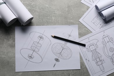 Different engineering drawings and pencil on gray textured table, top view