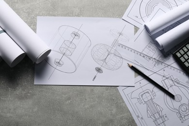 Different engineering drawings and tools on gray textured table, flat lay