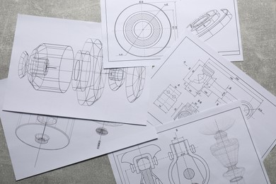 Photo of Different engineering drawings on gray textured table, top view