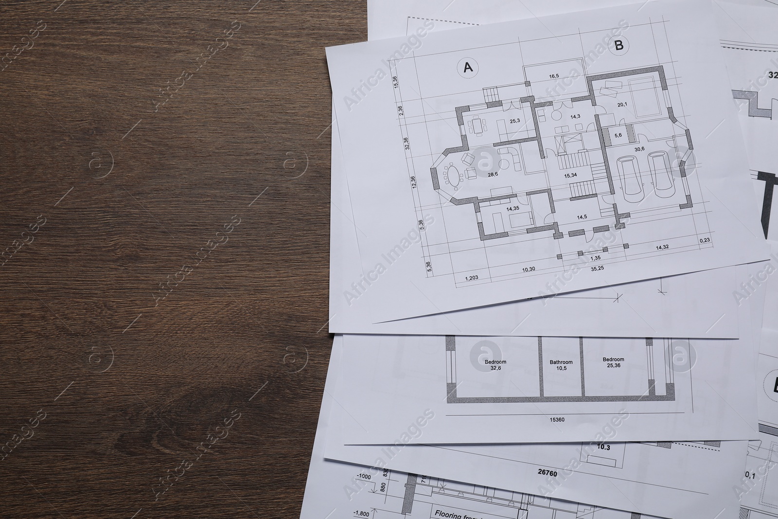 Photo of Different architectural drawings on wooden table, top view. Space for text