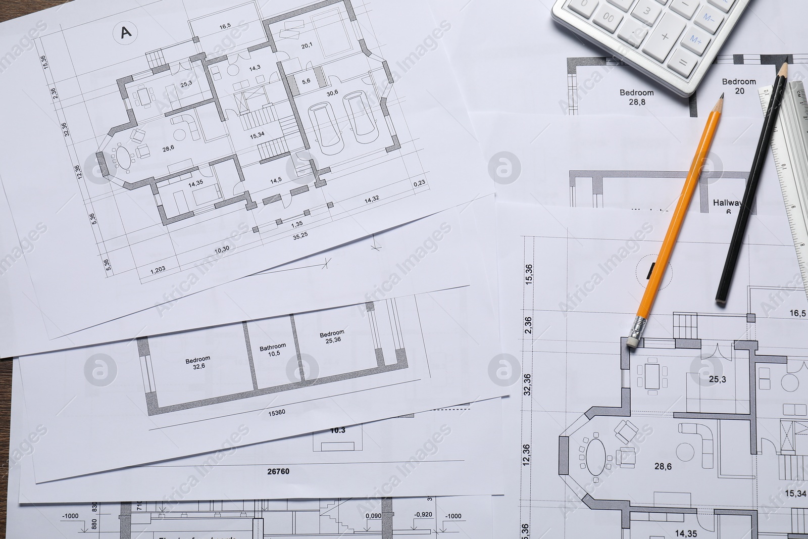 Photo of Different architectural drawings, calculator and pencils on table, top view